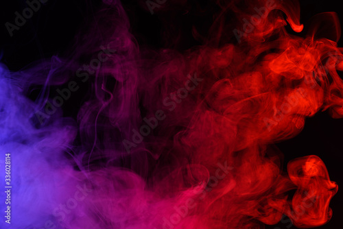 Colored smoke clouds flowing dark abstract background