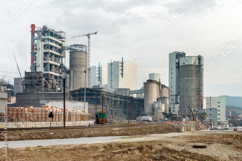 A view of a dirty dusty cement factory on sunrise. Industrial landscape