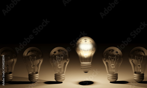 Outstanding glowing bulb in a line with many unlit ones. Concept of uniqueness and originality