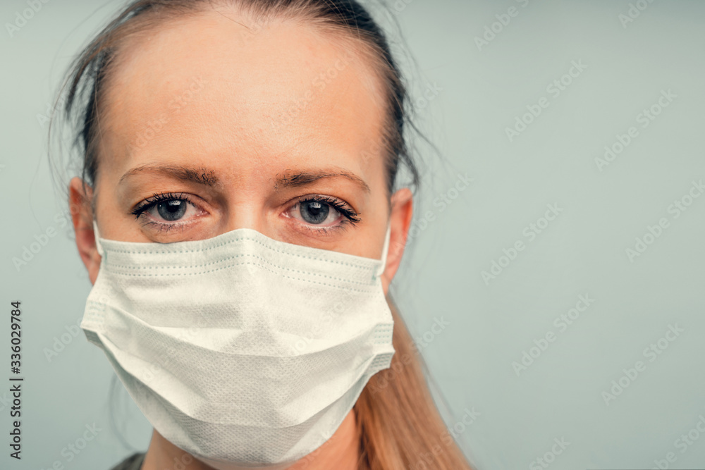 A girl is putting on a protective mask. Respiratory protection from coronavirus. Personal protective equipment for a pandemic of a viral infection. Covid-19. A girl is putting on a protective mask. Respiratory protection from coronavirus. Personal protective equipment for a pandemic of a viral infection. Covid-19.