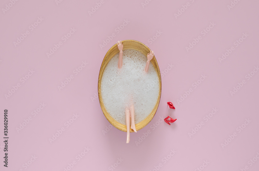 Doll bathing with bubble in wooden bathtub on pink background. Top view minimal beauty summer concept. - obrazy, fototapety, plakaty 