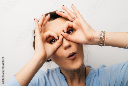 Pretty brunette girl shows glasses hands