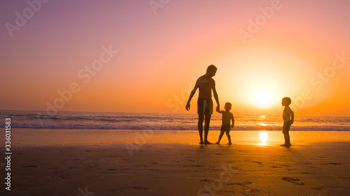 Father with kids playing in the beach at sunset © Quality Stock Video