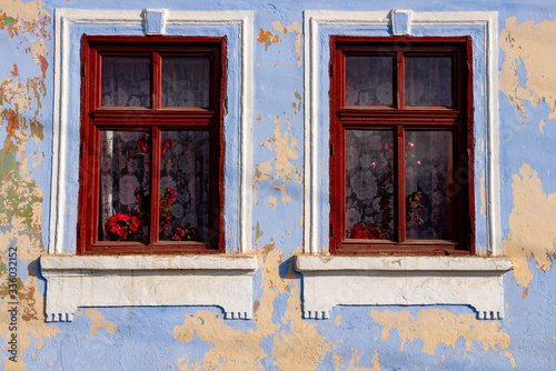 closed and open window of an old wooden house  traditional brown and red