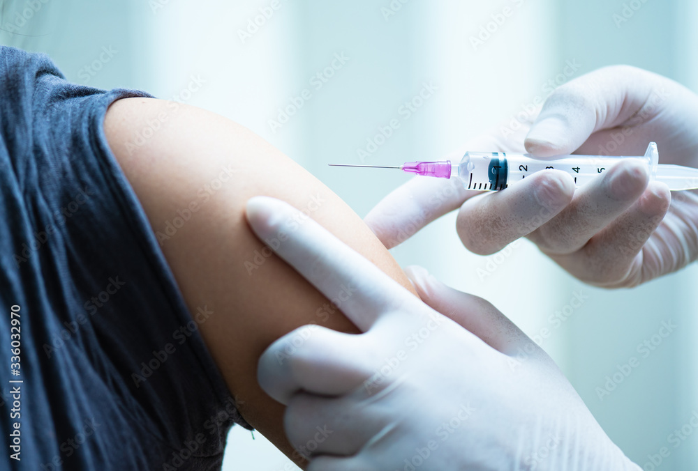 close up doctor's hand injecting for vaccination in the shoulder woman patient.Vaccine for protection HPV (Human Papillomavirus) infection.Vaccination for coronavirus treatment. close up doctor's hand injecting for vaccination in the shoulder woman patient.Vaccine for protection HPV (Human Papillomavirus) infection.Vaccination for coronavirus treatment.