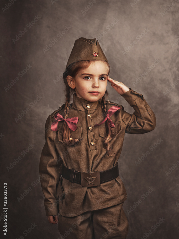 A child in military retro uniform salutes A child in military retro uniform salutes