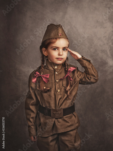 A child in military retro uniform salutes