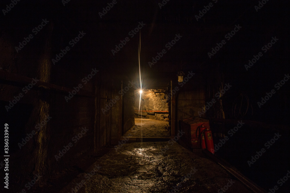 Underground gold quartz mine tunnel with light door