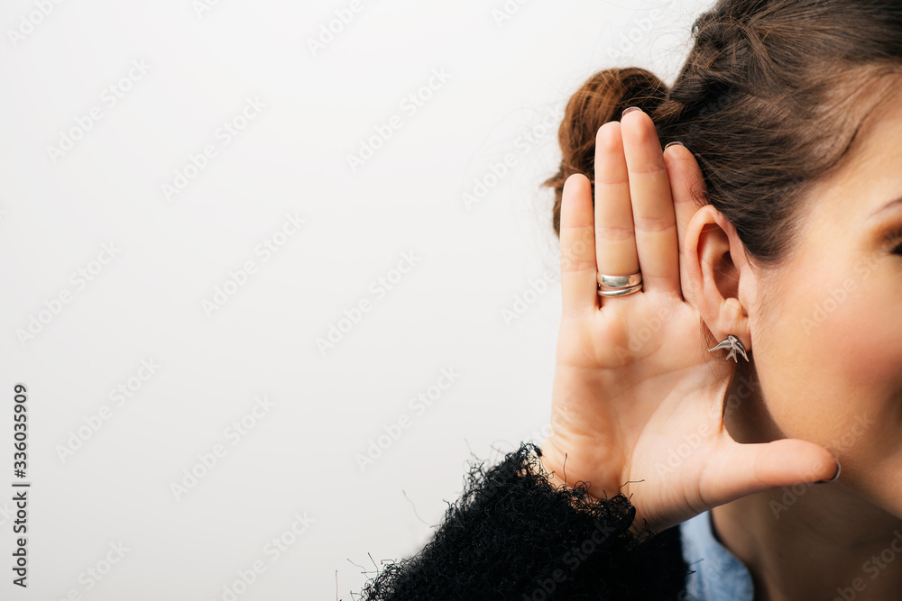 Closeup woman, girl with hand to ear listening secret gossip or quiet sound. Isolated on a white background