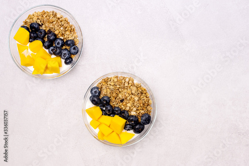 Bowls of Muesl and Yogurt with Berry and Mango Healthy Breakfast Diet Food Copy Space photo