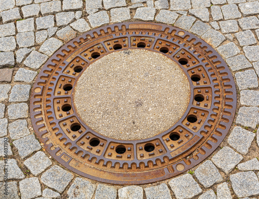 Studzienka kanalizacyjna. Właz do kanalow. Mealowa klapa. Wejscie do podziemi. Infrastruktura miasta. Kostki brukowe na ulicy. Beton i metal. Wodociagi miejskie. Studzienka kanalizacyjna. Właz do kanalow. Mealowa klapa. Wejscie do podziemi. Infrastruktura miasta. Kostki brukowe na ulicy. Beton i metal. Wodociagi miejskie.