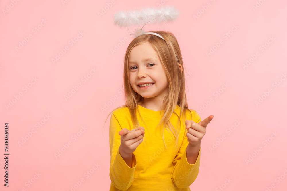 Φωτογραφία Hey you lucky! Happy cute positive little girl with angelic halo pointing fingers to camera and looking at camera with toothy smile, choosing you
