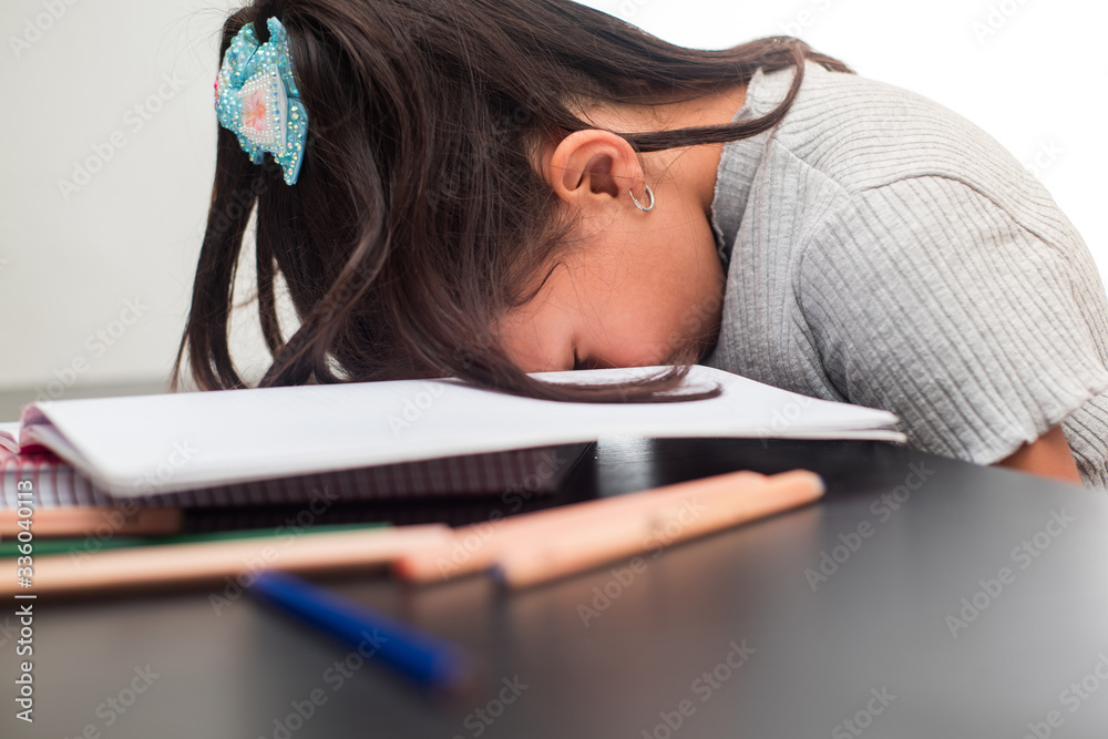 Foto de Lazy student girl at home, she is resting with her face down on the  school book. Concept of education and studying at home during quarantine.  do Stock | Adobe Stock