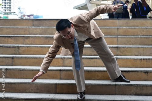 Business man with shocking face while fall down on the stair