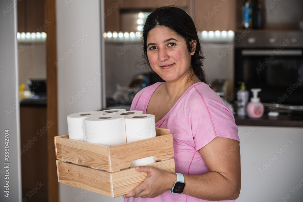 Young woman carrying a wooden box with toilet paper rolls