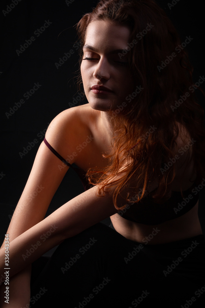 Portrait of a young curly girl in a dark studio Portrait of a young curly girl in a dark studio