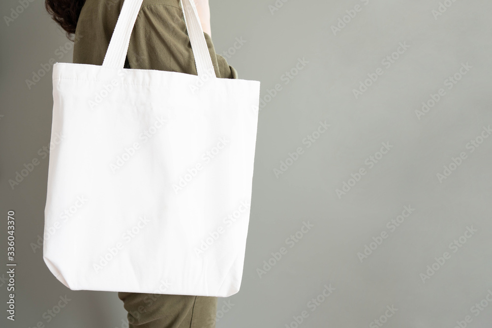 Blank white tote bag canvas fabric with handle mock up design. Close up of  woman holding