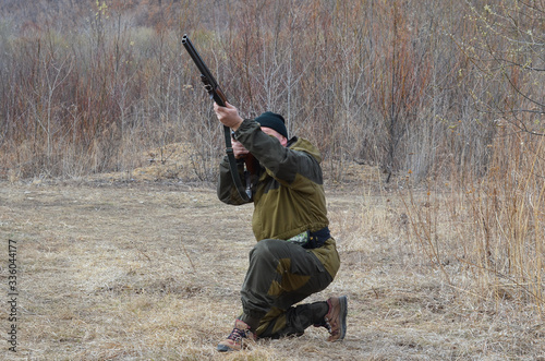 a man hunter shoots with a rifle in nature