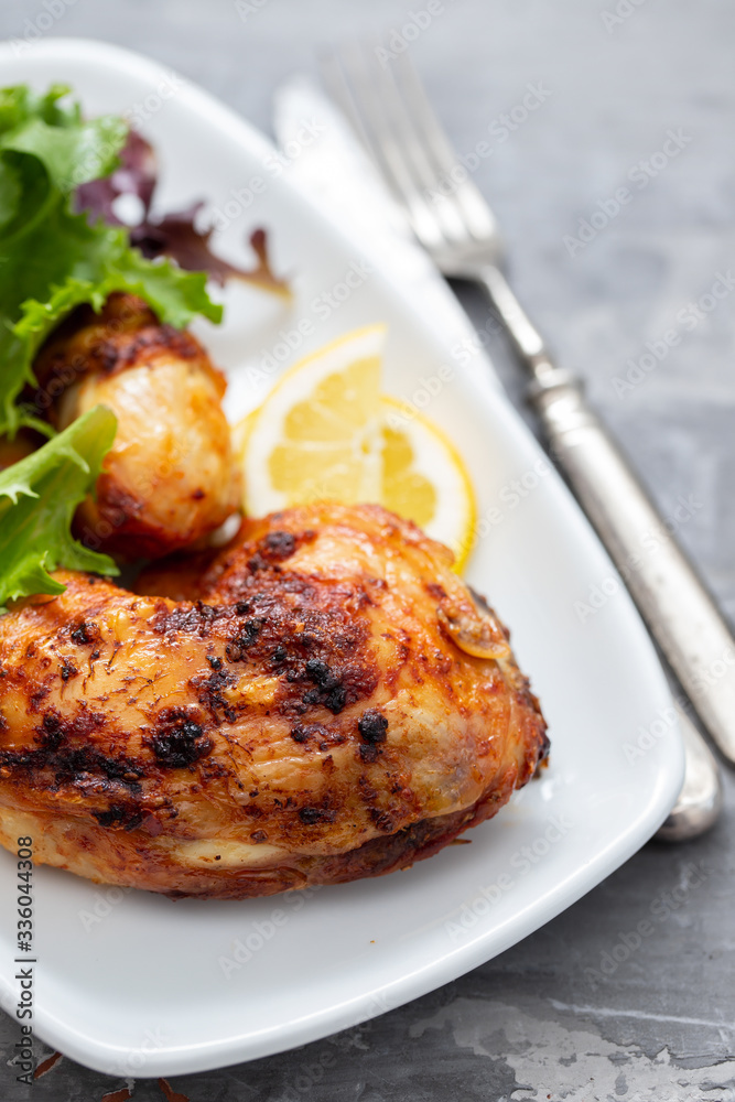 grilled chicken with lemon and salad on white dish grilled chicken with lemon and salad on white dish