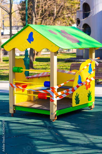 Children's playground closed and wrapped in alarm caution tape for global coronavirus quarantine