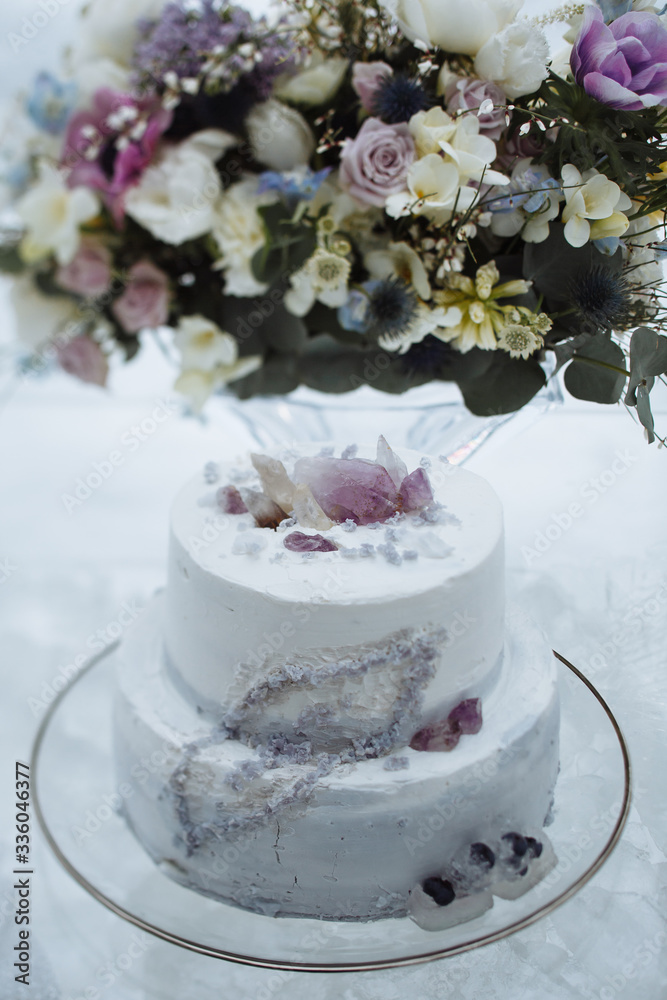 Glass table with a wedding bouquet, on which there is a wedding cake Glass table with a wedding bouquet, on which there is a wedding cake