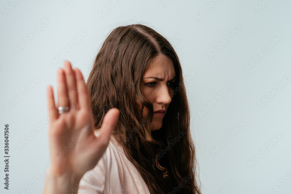 long-haired beautiful brunette girl shows stop, isolated on a white background long-haired beautiful brunette girl shows stop, isolated on a white background