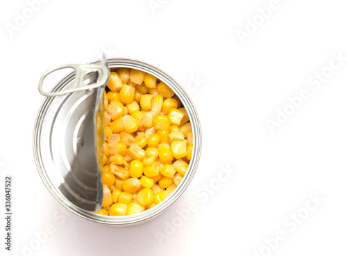 canned corn on a white background, open tin can, food preservation, space for text, close-up