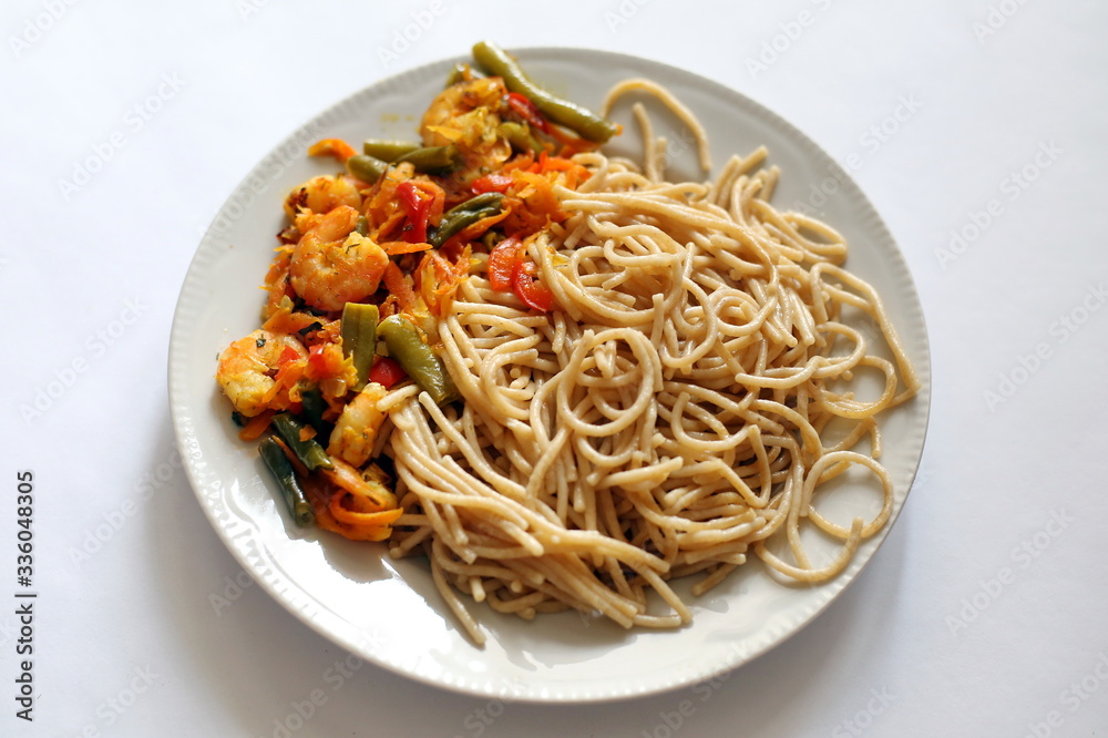 Spaghetti with fried vegetables and shrimp. Italian food. Eastern cuisine. Spaghetti with fried vegetables and shrimp. Italian food. Eastern cuisine.