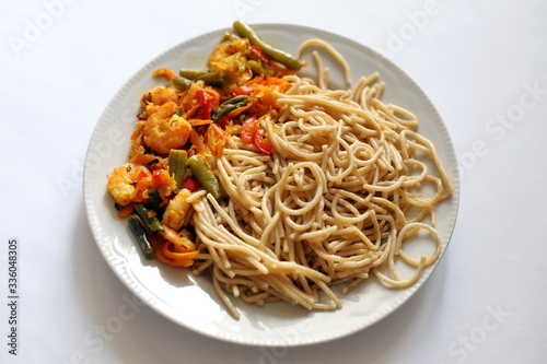 Spaghetti with fried vegetables and shrimp. Italian food. Eastern cuisine.