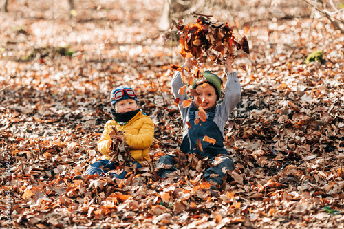 Kinder spielen im Laub im Wald 3