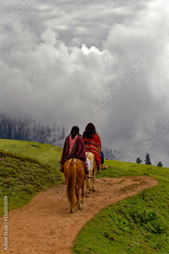 Two females riding horse in the green field © Mudassar