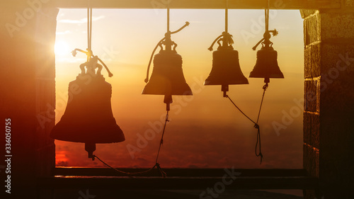 Bells at the Church on top of the Mount Athos in sinrise rays. Holy Mountain, Greece photo