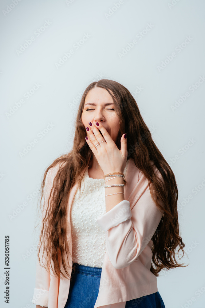 on a gray background young girl yawns on a gray background young girl yawns