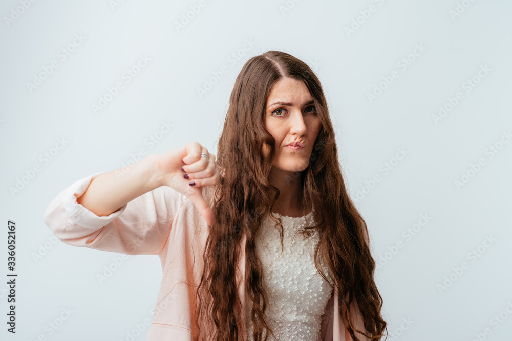 long-haired beautiful brunette girl showing thumb down isolated on white background long-haired beautiful brunette girl showing thumb down isolated on white background