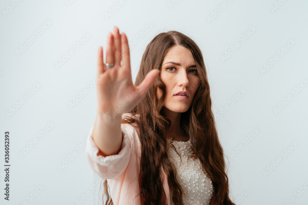 long-haired beautiful brunette girl showing stop isolated on white background long-haired beautiful brunette girl showing stop isolated on white background