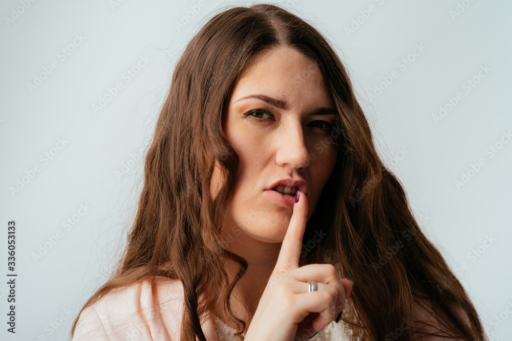 long-haired beautiful brunette girl asks quiet, isolated on a white background long-haired beautiful brunette girl asks quiet, isolated on a white background