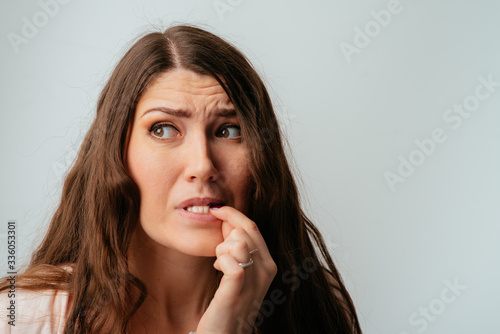 long-haired beautiful brunette girl bites his nails © aeroking