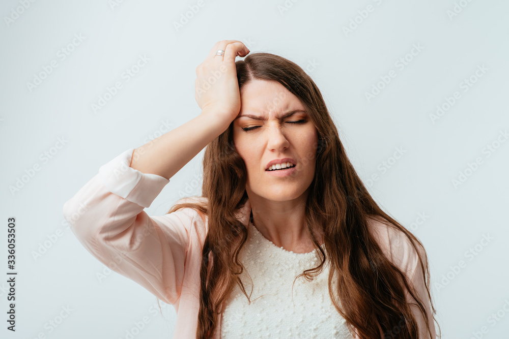 long-haired beautiful young brunette woman headache and holding on to the left side of the head long-haired beautiful young brunette woman headache and holding on to the left side of the head