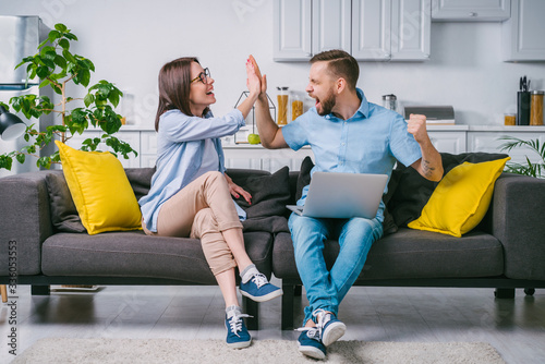 Young couple celebrating money win after betting online at bookmaker's website photo