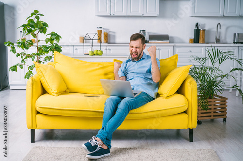 Attractive bearded man celebrating victory in online casino, guy supporting favourite soccer team cheering for goal photo