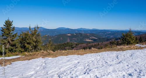 Meadows at the end of winter with snow and mountains in the background, beskydy czech
