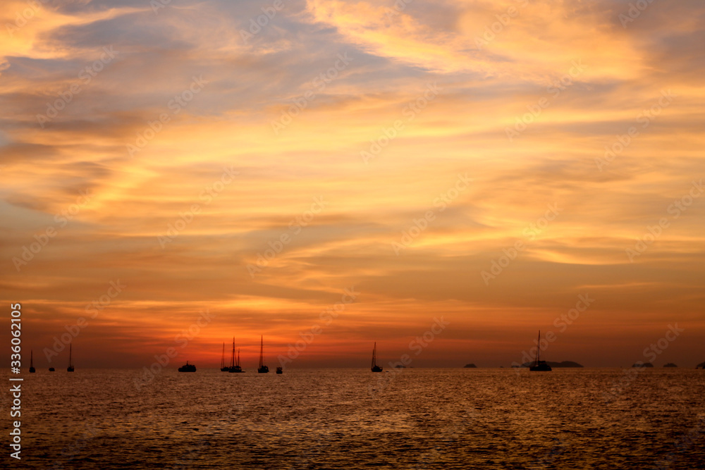 The sun was setting near dusk. See fishing boats See in the distance.