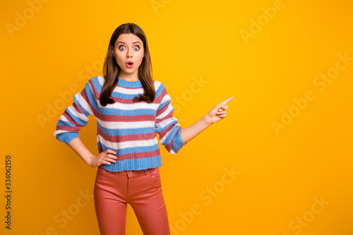 Photo of beautiful lady indicating finger empty space showing low prices season open mouth speechless wear casual striped pullover orange trousers isolated yellow color background © deagreez