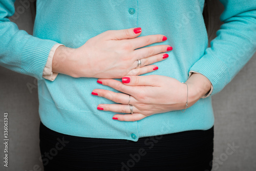 Young casual girl woman is having stomach ache