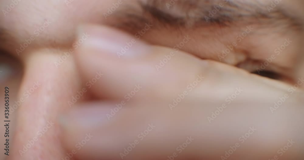 Close-up of a man looking at the screen with glasses and takes them off and rubs them from fatigue. Eye fatigue from the screen Close-up of a man looking at the screen with glasses and takes them off and rubs them from fatigue. Eye fatigue from the screen