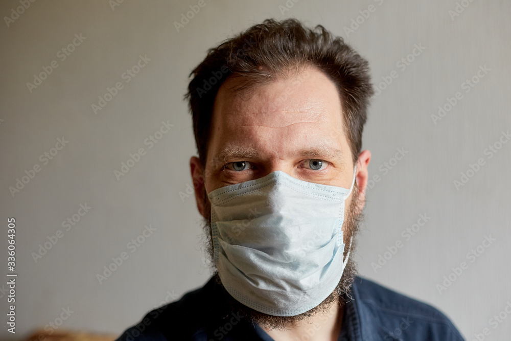 self-isolation and quarantine, portrait of a bearded man in a medical mask, protection from viruses and diseases self-isolation and quarantine, portrait of a bearded man in a medical mask, protection from viruses and diseases