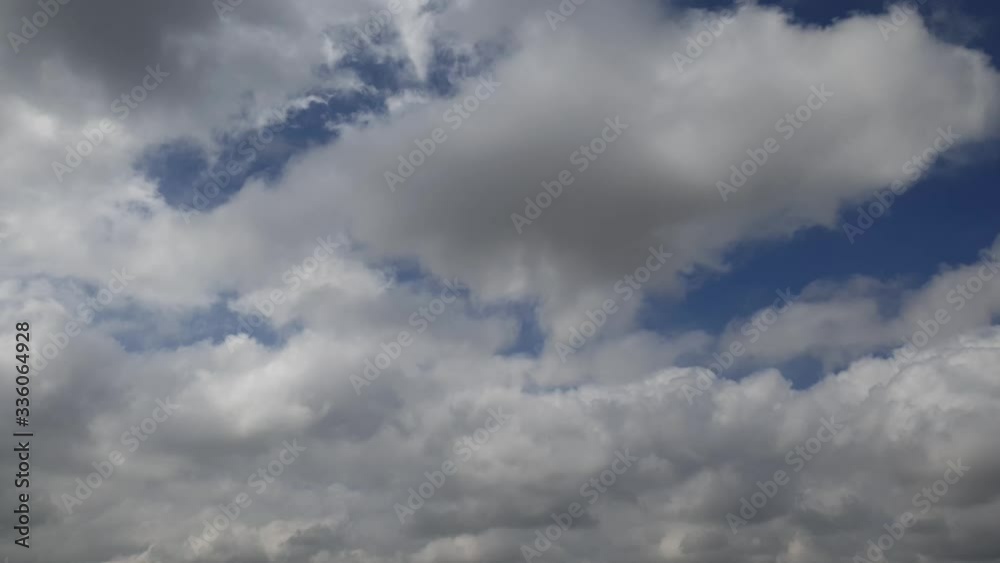 Blue summer sky with dense thick rain clouds moving across the heavens. Fast cloud formation and movement creating a surreal time lapse. Blue summer sky with dense thick rain clouds moving across the heavens. Fast cloud formation and movement creating a surreal time lapse.