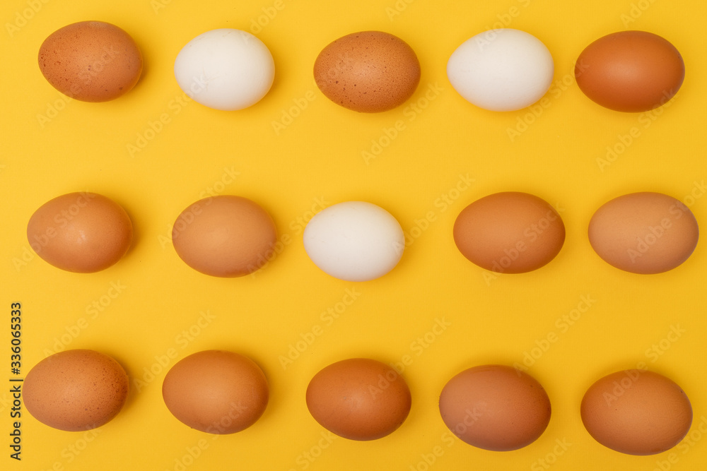 Easter eggs white, brown on a yellow background, place for an inscription in the center Easter eggs white, brown on a yellow background, place for an inscription in the center