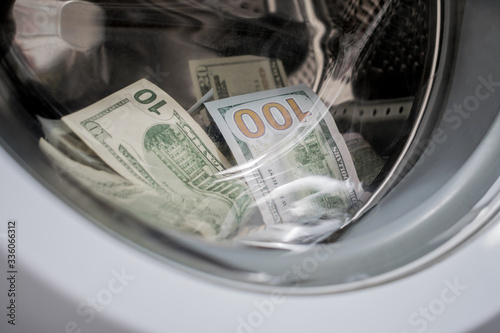 Money in an automatic washing machine are close-ups. Many banknotes are inside Washer. A lot of cash dollars is washed in the drum of a washing machine.
