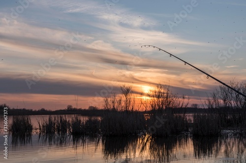 sunset over the river with fishing rod